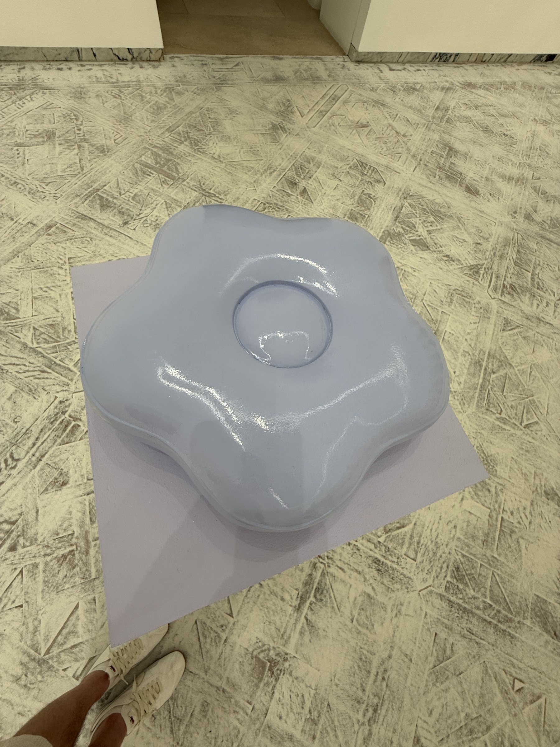 An oversized lavender flower sculpture on the floor