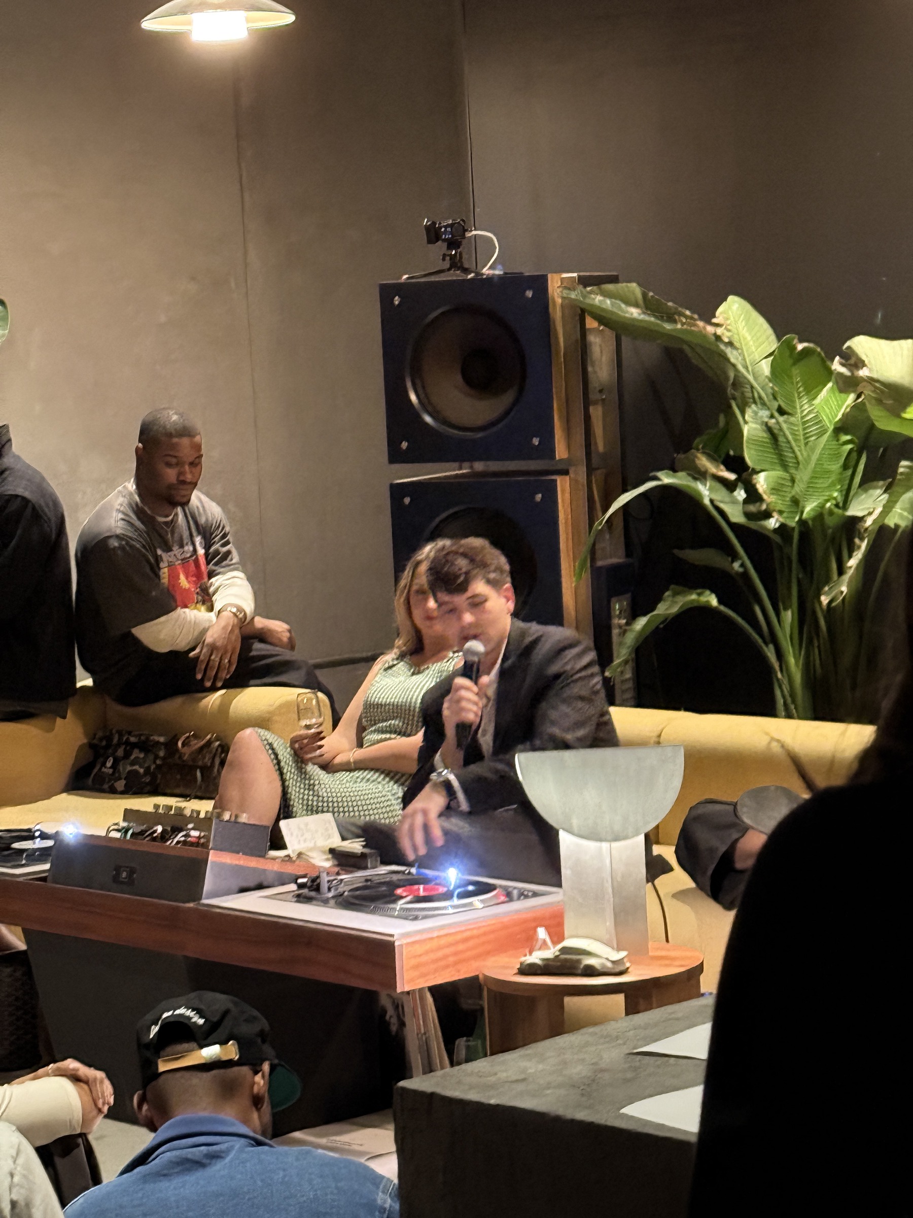 TADDEO on the couch with a microphone and turntables