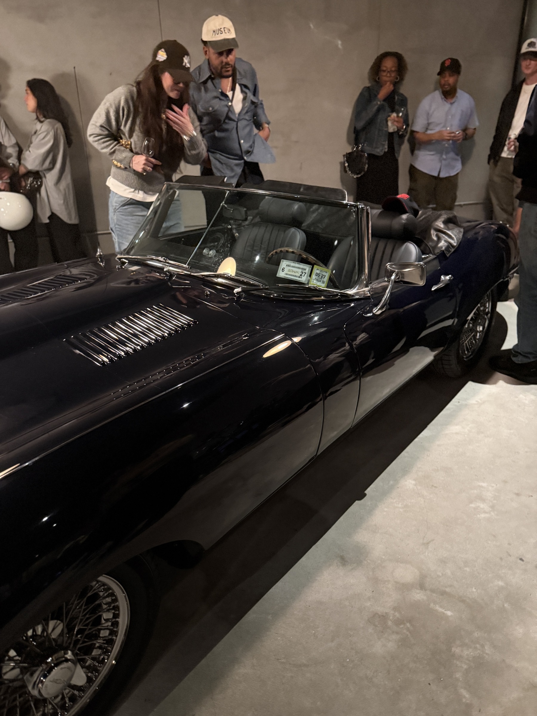 Two people leaning over the open Jaguar